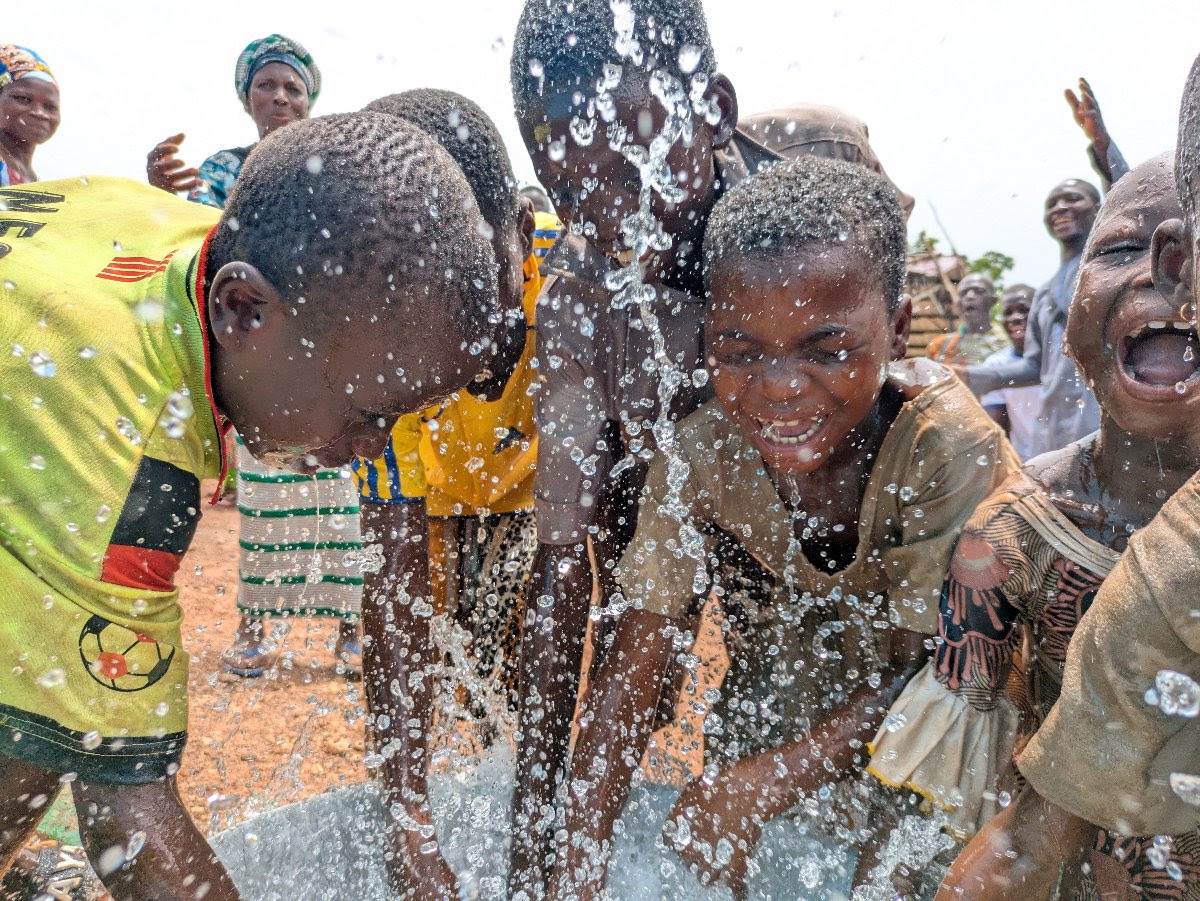 Children splashing and celebrating at a new Living Water well in Togo